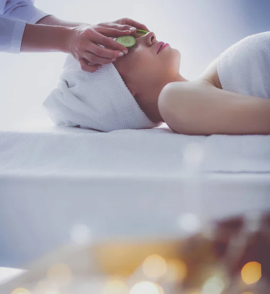 Mujer joven acostada en una mesa de masaje, relajándose con los ojos cerrados. Una mujer. Salón de spa — Foto de Stock