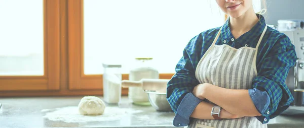 Молодая женщина, стоящая у плиты на кухне . — стоковое фото