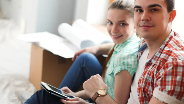 Casal em movimento em casa sentado no chão — Fotografia de Stock