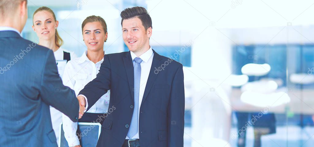 Full length image of two successful business men shaking hands with each other