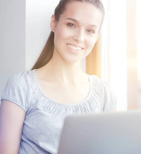 Joven hermosa mujer usando una computadora portátil en casa. Joven hermosa mujer . — Foto de Stock