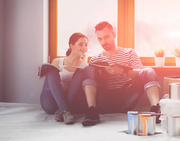 Casal em movimento em casa sentado no chão — Fotografia de Stock