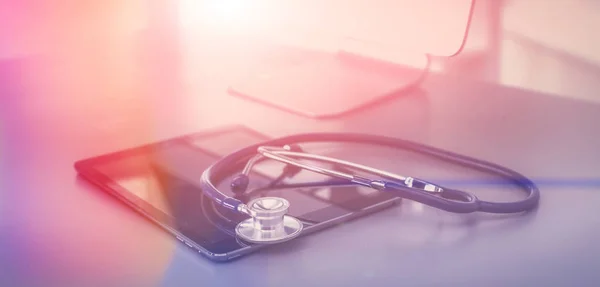 Medicinsk udstyr: blå stetoskop og tablet på hvid baggrund. Medicinsk udstyr - Stock-foto