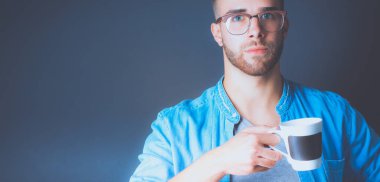 Ayakta ve elinde fincan kahve onun elinde portre yakışıklı genç adam