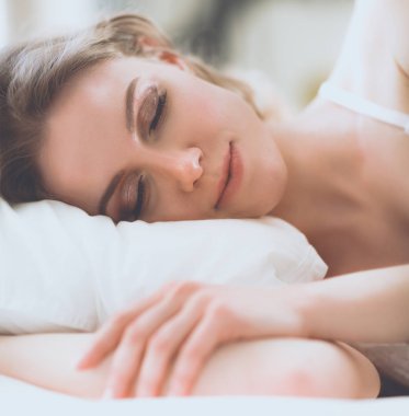 Güzel bir kadın yatağında uzanıyor..