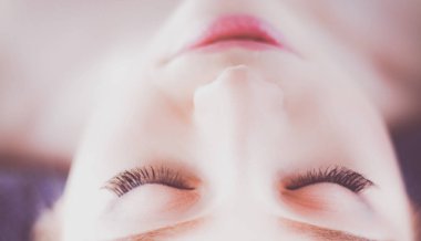 Masaj masasında uzanmış gözleri kapalı rahatlayan genç bir kadın. - Kadın. Spa salonu