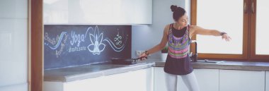 Formda ve çekici genç bir kadın sağlıklı yemek hazırlıyor. Kadın