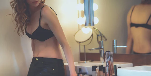 Young woman looking herself in the mirror on bathroom. — Stock Photo, Image