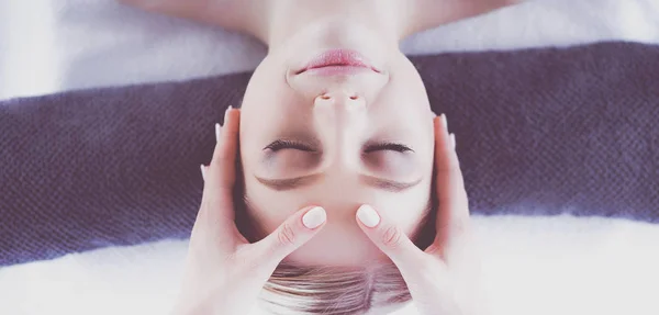 Giovane donna sdraiata su un tavolo da massaggio, rilassante con gli occhi chiusi. Una donna. Salone termale — Foto Stock