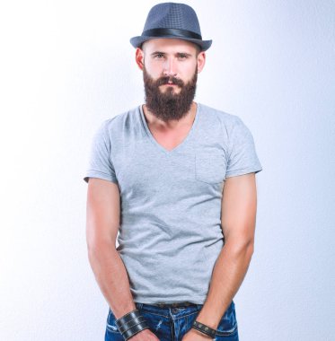 Beyaz arka plan üzerinde izole bir çanta, şapka ayakta yakışıklı sakallı adam portresi