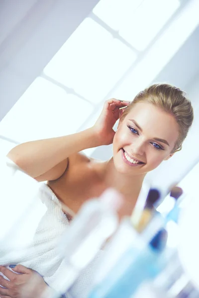Όμορφη κοπέλα κάνοντας make-up κοντά καθρέφτη, κάθεται στο γραφείο — Φωτογραφία Αρχείου