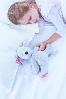 çocuk oyuncak oyuncak ayı ile yatakta uyur küçük kız