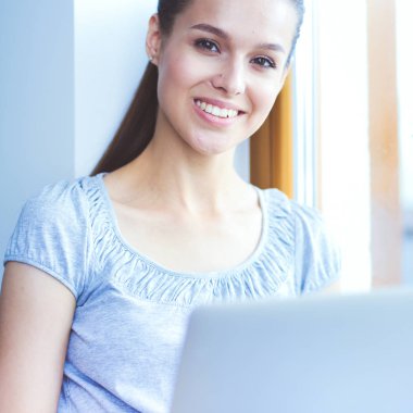 Evde bir dizüstü bilgisayar kullanan genç güzel kadın. Genç güzel kadın.