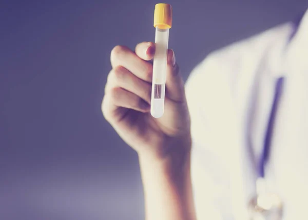 Cientista ou médica de investigação feminina ou médica que utiliza um tubo de ensaio de solução límpida num laboratório ou laboratório . — Fotografia de Stock