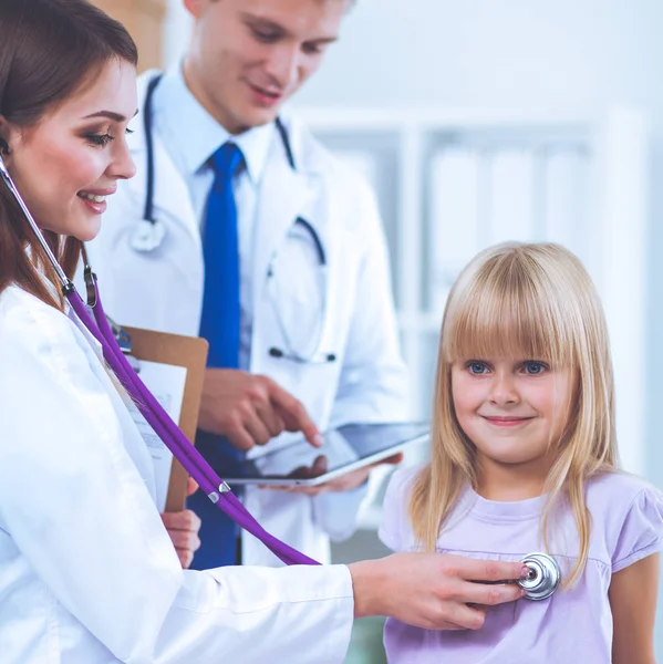 Médico femenino examinando a un niño con estetoscopio en cirugía —  Fotos de Stock