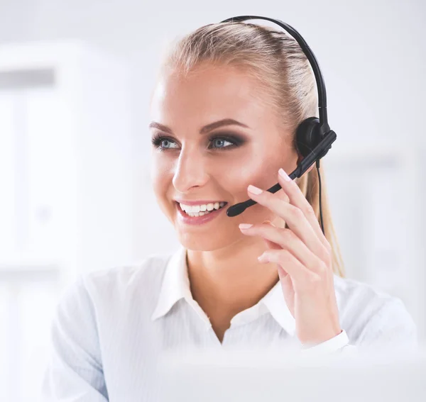 Portrait of beautiful businesswoman working at her desk with headset and laptop — Stock Photo, Image