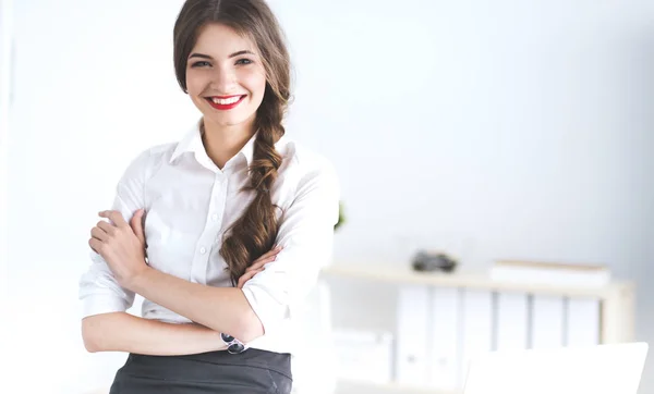 Attraente donna d'affari con le braccia incrociate in piedi in ufficio — Foto Stock