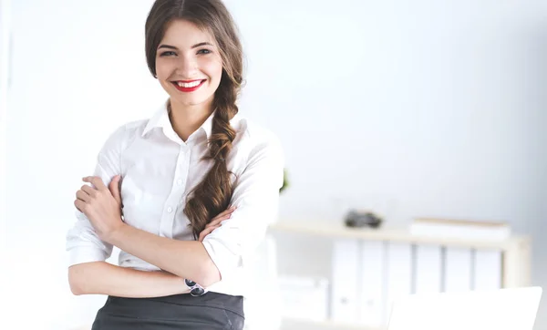 Attractive businesswoman with her arms crossed  standing in office Stock Photo
