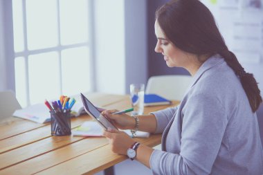 Ofiste modern dijital tablet kullanan güzel bir bayan yönetici.