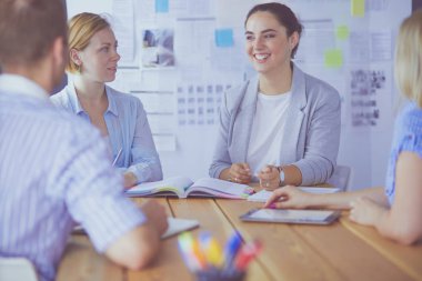 Masada kitaplarla çalışan gençler. Güzel kadınlar ve erkekler birlikte çalışıyor.