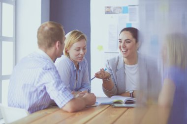 Masada kitaplarla çalışan gençler. Güzel kadınlar ve erkekler birlikte çalışıyor.