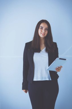 Genç iş kadını onun elinde dijital tablet ile gülümseyen portresi