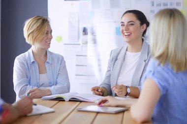 Masada kitaplarla çalışan gençler. Güzel kadınlar ve erkekler birlikte çalışıyor.