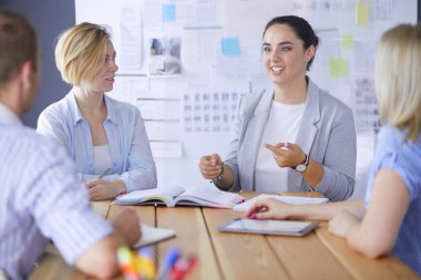 Masada kitaplarla çalışan gençler. Güzel kadınlar ve erkekler birlikte çalışıyor.