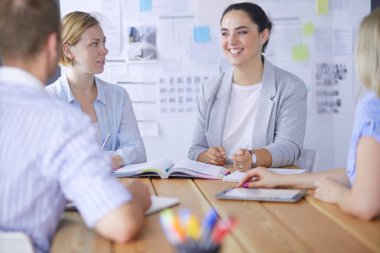 Masada kitaplarla çalışan gençler. Güzel kadınlar ve erkekler birlikte çalışıyor.