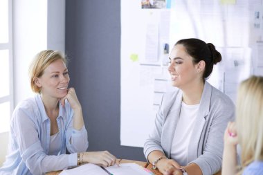 Masada kitaplarla çalışan gençler. Güzel kadınlar ve erkekler birlikte çalışıyor.