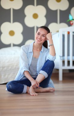 Genç kadın lotus pozisyonunda evde Yoga yapıyor. Genç kadın yoga yaparken.