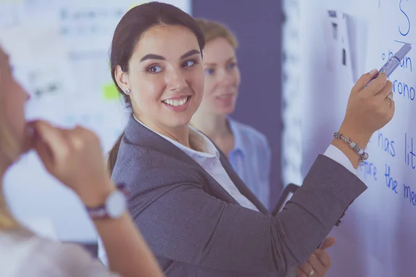 Business, education and office concept - business team with flip board in office discussing something — Stock Photo, Image