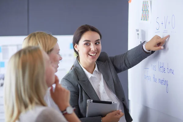 Concepto de negocio, educación y oficina - equipo de negocios con flip board en la oficina discutiendo algo —  Fotos de Stock