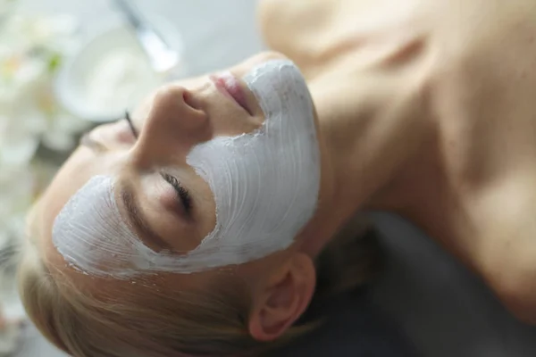 Mascarilla facial. Hermosa joven en el spa, mujer cosmética aplicando mascarilla facial . —  Fotos de Stock