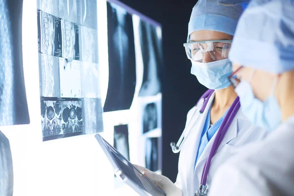 Twee vrouwelijke artsen die röntgenfoto 's bekijken in een ziekenhuis. — Stockfoto