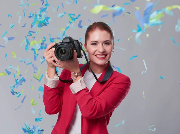 Hermosa mujer feliz con cámara en la fiesta de celebración con confeti. Cumpleaños o Nochevieja celebrando el concepto — Foto de Stock