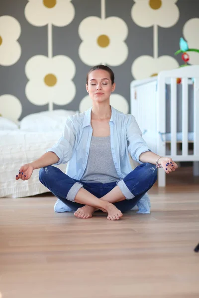 Young woman doing yoga at home in the lotus position. Young woman doing yoga. — Stock Photo, Image