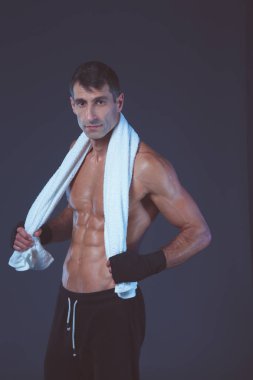 Siyah arka plan üzerine ayakta güçlü atletik adam.