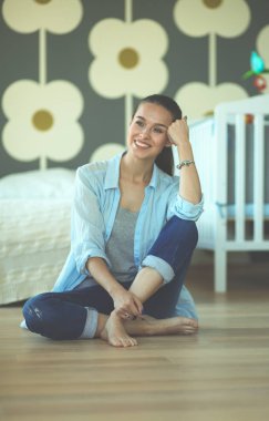 Genç kadın lotus pozisyonunda evde Yoga yapıyor. Genç kadın yoga yaparken.