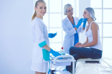 Güzel kadın elinde şırıngayla doktorun yanında duruyor..