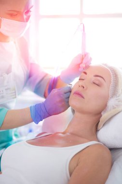 Kaşlar için kalıcı makyaj. Güzellik salonunda kalın kaşlı güzel bir kadın..