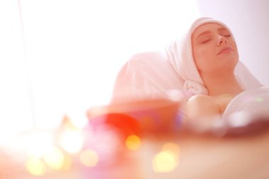 Masaj masasında uzanmış gözleri kapalı rahatlayan genç bir kadın. - Kadın. Spa salonu