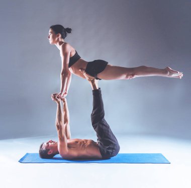 Genç çift Acro yoga mat Studio birlikte uygulamak. Acroyoga. Çift yoga. Ortak yoga.