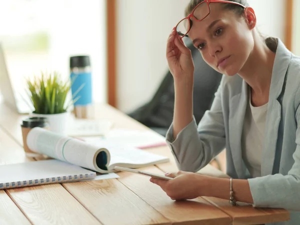 Affärskvinna sitter på sitt kontor med hjälp av en surfplatta dator. — Stockfoto