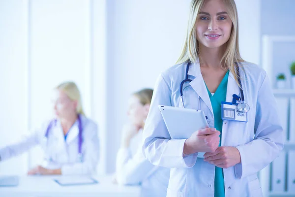 Retrato de una joven doctora, con almohadillas en la mano, en un consultorio médico —  Fotos de Stock