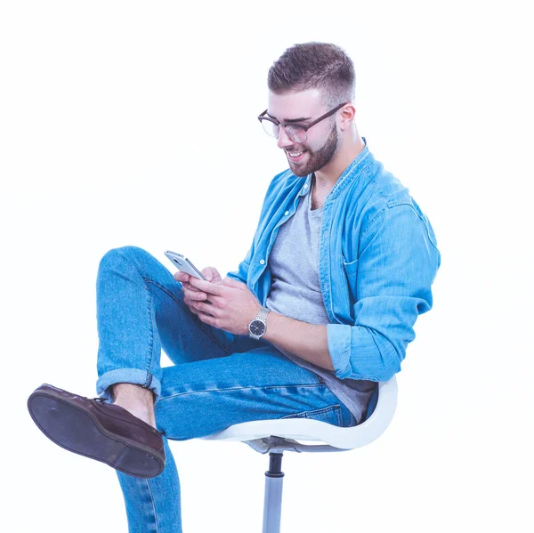 Jeune homme assis sur une chaise et utilisant un téléphone portable. Démarreur. Jeune entrepreneur . — Photo