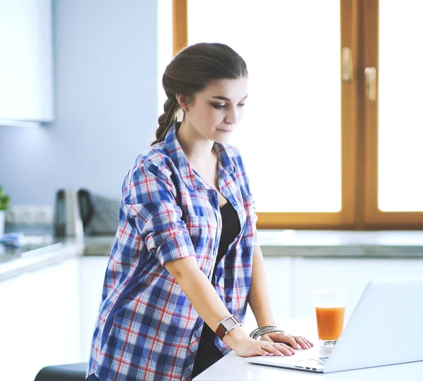 Mooie jonge glimlachende vrouwelijke arts zitten aan het bureau en schrijven. — Stockfoto