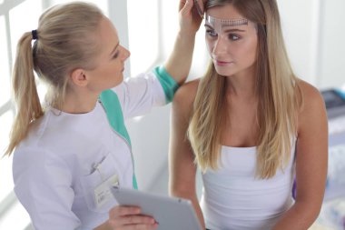 Kaşlar için kalıcı makyaj. Güzellik salonunda kalın kaşlı güzel bir kadın..