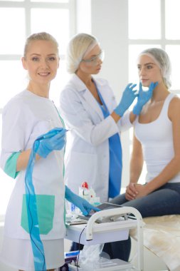 Güzel kadın elinde şırıngayla doktorun yanında duruyor..