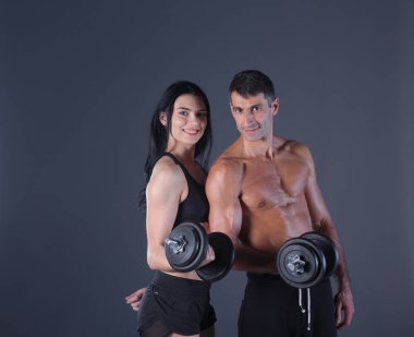 Atletik erkek ve kadın salak-bells ile. Kişisel fitness eğitmeni. Kişisel eğitim. Ağırlık çalışması. Egzersiz.